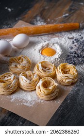 Homemade fettuccine pasta folded in the shape of a nest. Home cooking with ingredients for homemade traditional Italian fettuccine pasta. - Shutterstock ID 2062386260