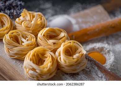 Homemade fettuccine pasta folded in the shape of a nest. Home cooking with ingredients for homemade traditional Italian fettuccine pasta. - Powered by Shutterstock