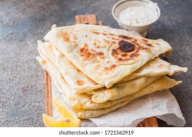 Homemade Flatbread Stuffed With Potato, Herbs And Cheese With Yogurt Sauce And Lemon. Close Up And Overhead View.