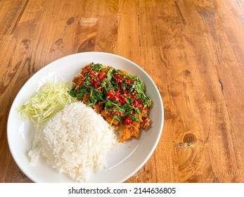 Homemade food, Fried pork cutlet top on stir fried basil sauce with shredded cabbage. (Tonkatsu stir fried basil rice)