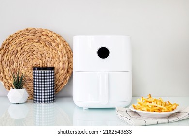 Homemade french fries in modern airfryer, do-it-yourself home cooking concept - Shutterstock ID 2182543633