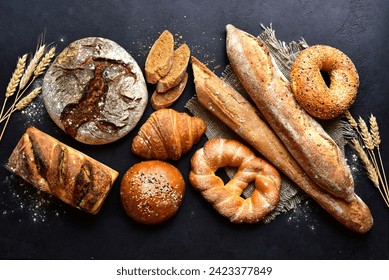 Homemade fresh baked bread with flour and ears on a black background. Top view with copy space. - Powered by Shutterstock