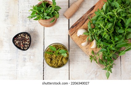 Homemade Fresh Herbal  Italian Pesto Sauce, Green Basil Leaves, Pine Nuts, Garlic, Black Pepper And Olive Oil Served In Glass Bowl On Wooden Background