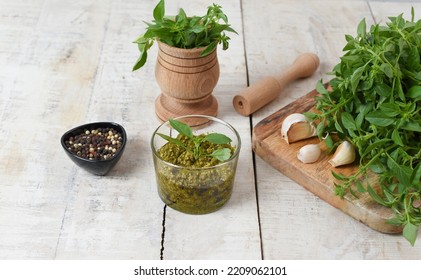 Homemade Fresh Herbal  Italian Pesto Sauce, Green Basil Leaves, Pine Nuts, Garlic, Black Pepper And Olive Oil Served In Bowl On Wooden Background