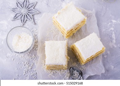 Homemade fresh sponge cake in the coconut cream and coconut flakes on the feast served in portions on a gray background. selective focus - Powered by Shutterstock