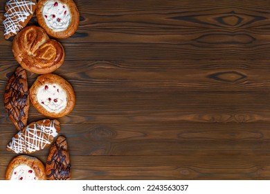 Homemade freshly baked bread. Wood rustic table, board. Bakery baked goods bars, baguette, buns, rolls, biscuits and loaf breads, cookies, cakes, cheesecakes and pies, muffins. Top view, copy space. - Powered by Shutterstock