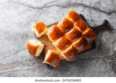 Homemade Freshly baked soft Dinner Rolls or Hawaiian Buns closeup on the wooden board on the table. Horizontal top view from above
 - Powered by Shutterstock