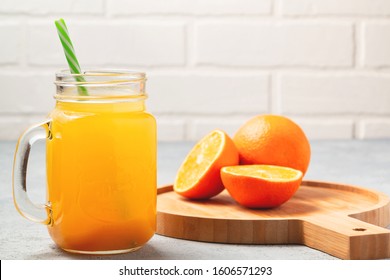 Homemade freshly squeezed orange juice in a mason jar, oranges on wooden dish closeup, copyspace - Shutterstock ID 1606571293