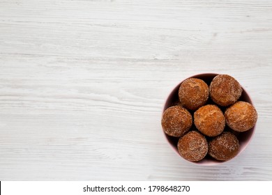 Homemade Fried Donut Holes In A Pink Bowl On A White Wooden Background, Top View. Flat Lay, Overhead, From Above. Copy Space.