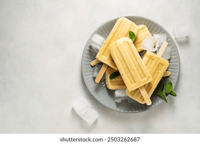 Homemade fruit yellow popsicles with mango, banana, pineapple. Top view.  - Powered by Shutterstock