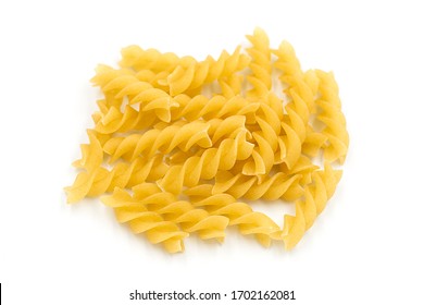 Homemade fusilli pasta heap on white isolated background in macro top view. Fusilli have spiral shape and yellow color. Pasta is delicious Italian traditional food made from wheat flour like noodles.