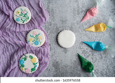 Homemade Gingerbread Cookie In The Shape Of Flowers. Process Of Decorating Spring Gingerbread Cookies (flowers) With Colored Icing, Spring Flowers And Place For Text. Flat Lay. Copy Space.