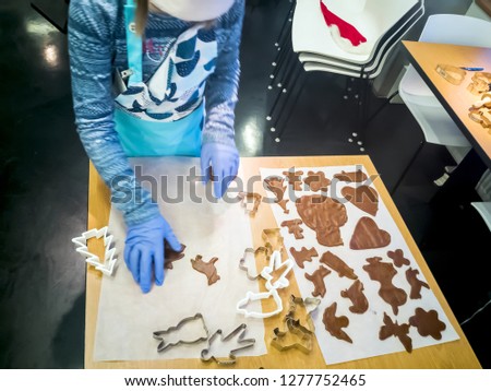 Homemade gingerbread cookies with shapes, cutting, overhead composition. Children decorate cookies with colored glaze. preparing for christmas. Concept of preparation for holidays and happy new year