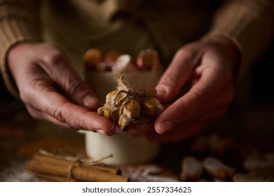 Homemade gingerbread cookies tied with twine, held during festive warm celebrations in a cozy setting. - Powered by Shutterstock