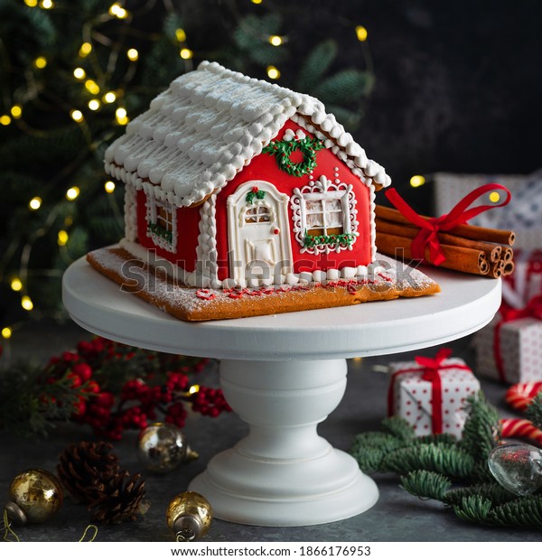 Homemade gingerbread\
house. Christmas concept. Gingerbread house, cookies, car with tree\
on the background