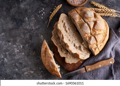 Homemade gluten free bread on a napkin on the kitchen table - Shutterstock ID 1690361011