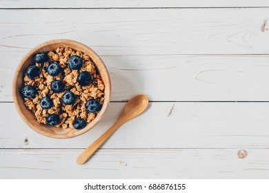 Homemade granola and fresh berries on wood table with space. - Shutterstock ID 686876155