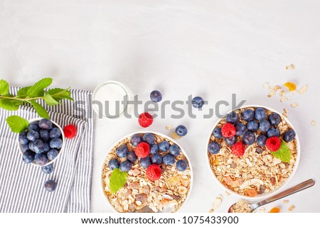 Homemade granola or oatmeal muesli with nuts, dried fruits and fresh berries. Healty diet breakfast, vegeterian food concept