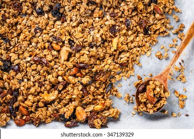 homemade granola with raisins and nuts on a baking sheet