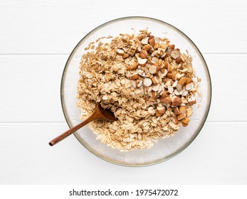 Homemade Granola. Step By Step Cooking. Almond, Dried Cranberry, Walnut And Hazelnut Rolled Oats Muesli. Tasty Healthy Breakfast. Step 3. Add Chopped Almonds And Nuts In Bowl With Oat Flakes And Honey