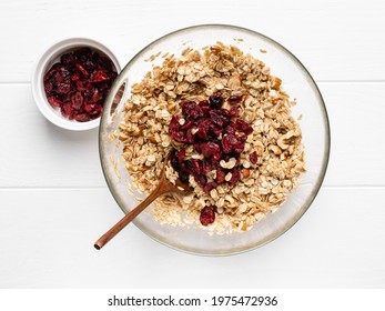 Homemade Granola. Step By Step Cooking. Almond, Dried Cranberry, Walnut And Hazelnut Rolled Oats Muesli. Tasty Healthy Breakfast. Step 4. Add Dried Cranberry In Bowl With Oat Flakes, Honey, Oil, Nuts.