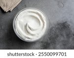 Homemade Greek Yogurt in bowl on rustic stone background, top view, copy space. Organic plain greek yogurt, labneh cream cheese, sour cream for healthy breakfast.