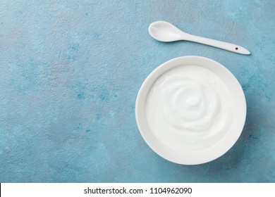 Homemade Greek Yogurt In Bowl On Blue Stone Table Top View.