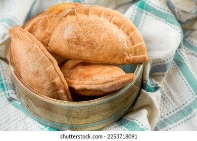 Homemade grilled cheese empanada, on a tablecloth of four. four cheese empanadas on an ando plate - Shutterstock ID 2253718091