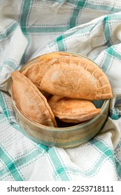 Homemade grilled cheese empanada, on a tablecloth of four. four cheese empanadas on an ando plate - Shutterstock ID 2253718111