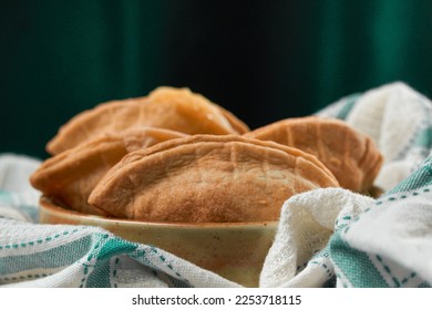 Homemade grilled cheese empanada, on a tablecloth of four. four cheese empanadas on an ando plate - Shutterstock ID 2253718115