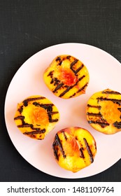 Homemade Grilled Peaches On A Pink Plate On A Black Background, Top View. Flat Lay, Overhead, From Above. 