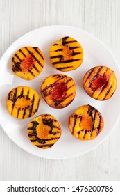 Homemade Grilled Peaches On A White Plate On A White Wooden Surface, Top View. Flat Lay, From Above, Overhead.