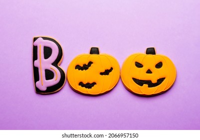 Homemade Halloween Cookies Pumpkins On Purple Background.