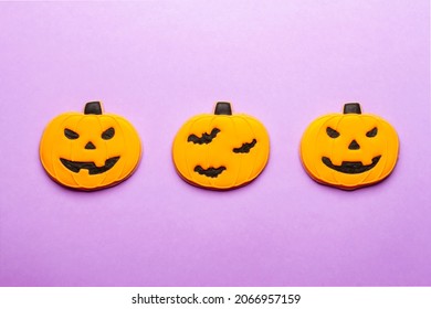 Homemade Halloween Cookies Pumpkins On Purple Background.