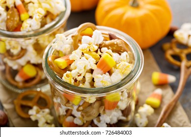 Homemade Halloween Trail Or Snack Mix With Candycorn, Popcorn, Pretzels And Nuts In Glass Jars