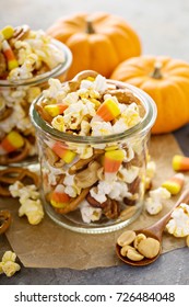 Homemade Halloween Trail Or Snack Mix With Candycorn, Popcorn, Pretzels And Nuts In Glass Jars