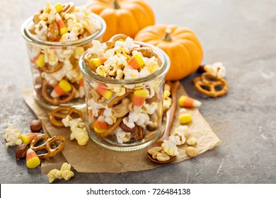 Homemade Halloween Trail Or Snack Mix With Candycorn, Popcorn, Pretzels And Nuts In Glass Jars