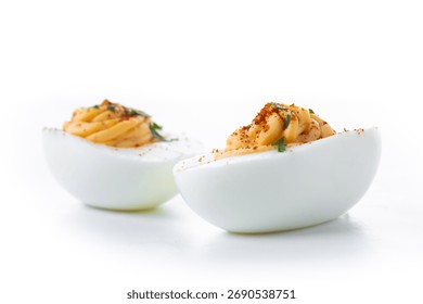 Homemade hard Boiled Deviled Eggs garnished with herbs isolated on white background