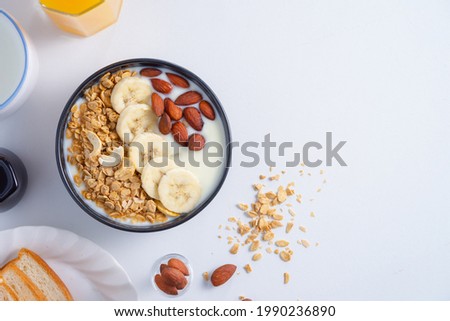homemade healthy breakfas,Bowl with greek yogurt, banana granola and almonson,milks and orange juice and bread on white background.top view.