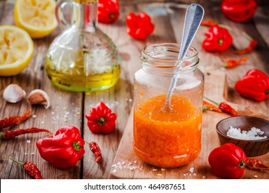 Homemade Hot Chili And Habanero Sauce On Wooden Table