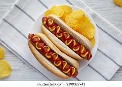 Homemade Hot Dog With Ketchup And Yellow Mustard With Chips On A Plate, Top View. Flat Lay, Overhead, From Above.