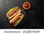 Homemade hot dogs with sausage, green salad, cucumber and red onion on the black background top view, copy space for text. High quality photo