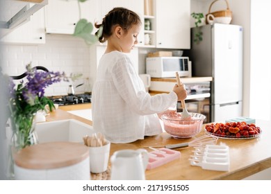 Homemade ice cream. Cute little girl preparing homemade strawberry ice cream at the kitchen. Summer food. - Shutterstock ID 2171951505