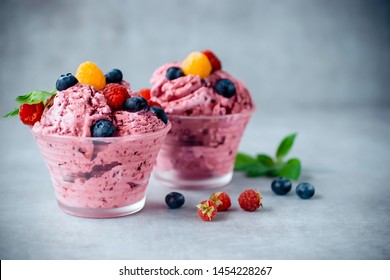 Homemade ice cream made from fresh berries with basil in glass bowl on a gray background. Soft focus. - Shutterstock ID 1454228267