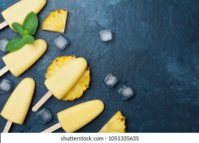 Homemade ice cream or popsicles from pineapple decorated with mint leaf. Top view. Frozen fruit pulp. Summer sweets.  - Powered by Shutterstock