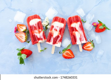Homemade ice cream popsicles with strawberries and cream