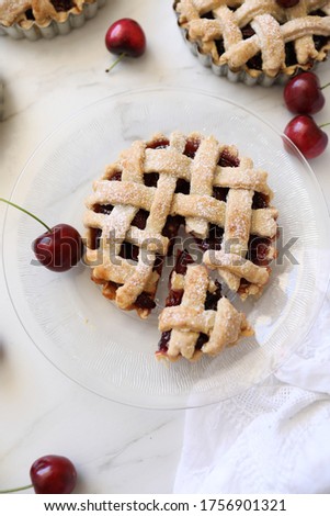 Homemade individual Lattice Cherry pie. Simple, delicious patisserie, home rustic baking, summer french dessert concept. Top view, flat lay, Copy space  