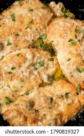 Homemade Italian Chicken Piccata In A Cast Iron Pan, Top View. Overhead, From Above, Flat Lay. Close-up.