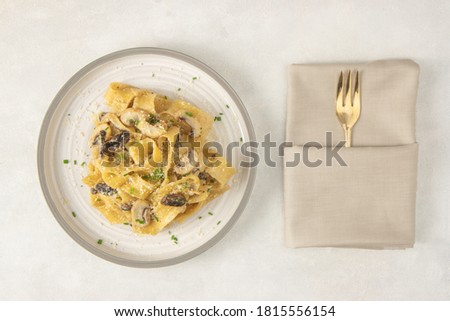 Homemade Italian fettuccine pasta with mushrooms and parmesan (Fettuccine al Funghi Porcini). Traditional Italian cuisine. Served with on white background. Top view.