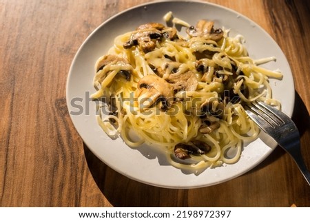 Homemade Italian fettuccine pasta with mushrooms and cream sauce (Fettuccine al Funghi Porcini). Traditional Italian cuisine. High quality photo